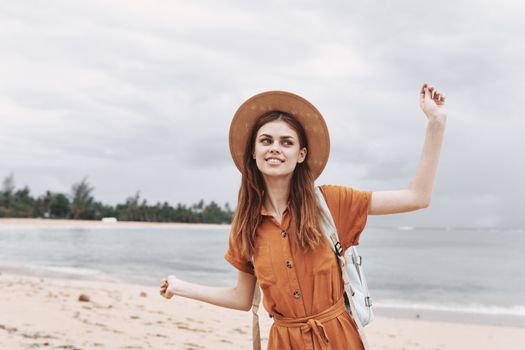 Happy woman in a hat travels on an island near the ocean