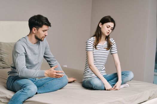 Young people sort things out on the bed indoors