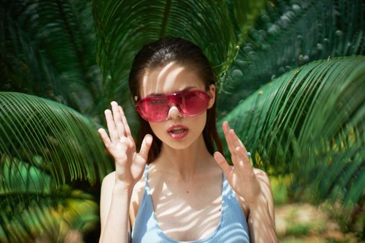 A woman is resting on an island near green leaves and gesturing with her hands