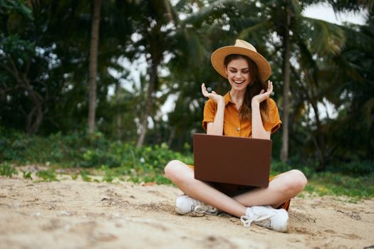 Happy woman on vacation with laptop on her lap