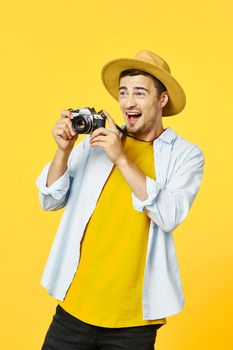 Happy photographer with a camera in his hands and looks away on an isolated background