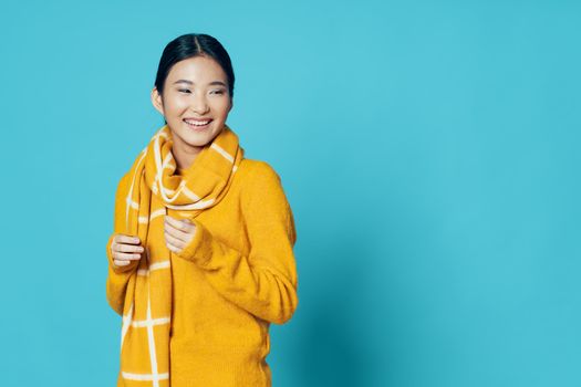 Happy woman in a warm sweater and a scarf around her neck free place