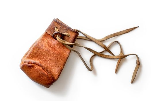 Small old worn brown leather coin pouch, isolated on white background.