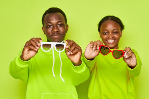 man holds glasses in his face and a happy woman of African appearance