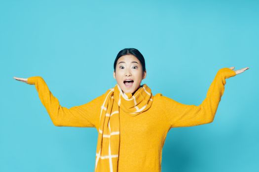 Happy woman in a yellow sweater spreads her arms to the sides