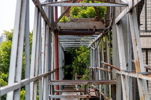 Pedestrian overpass in old factory. rusty metal, dangerous place. Metal structure