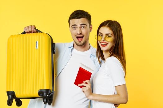 A woman with a passport and tickets is standing next to a man with a suitcase traveling tourism