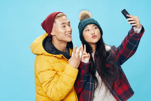 A woman of Asian appearance with a mobile phone is photographed on camera