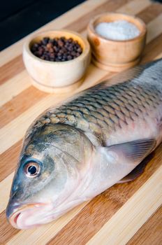 Uncooked fish on cutting board in meal preparation concept