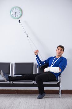 Desperate man waiting for his appointment in hospital with broken arm