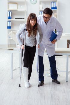 Doctor examining patient with broken leg