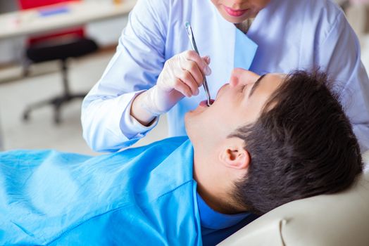 Woman dentist doctor with male patient in hospital