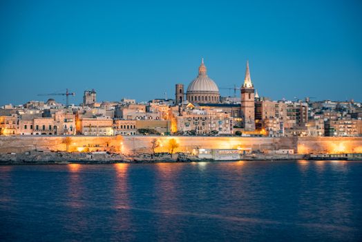 Panoramic view of Valletta Skyline at beautiful sunset from Sliema with churches of Our Lady of Mount Carmel and St. Paul's Anglican Pro-Cathedral, Valletta, Capital city of Malta