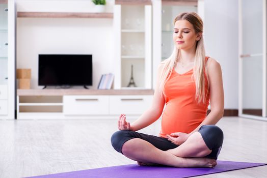 Pregnant woman doing sport exercise at home