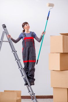 Woman painter painting in new apartment