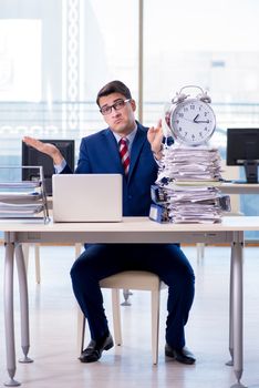 Businessman employee in urgency and deadline concept with alarm clock
