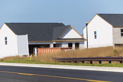 Horizontal shot of two homes under construction.