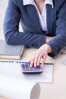 Female finance professional working on keyboard with reports