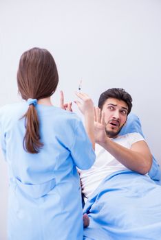 Woman doctor examining male patient in hospital