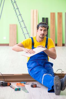 Professional contractor laying flooring at home