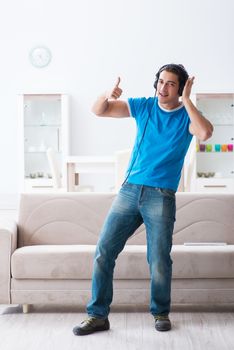 Young handsome man listening to the music and having fun at home 