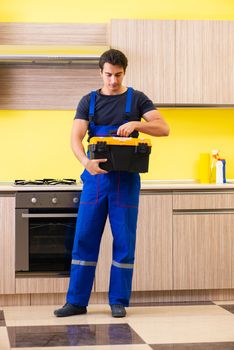 Young service contractor assembling kitchen furniture