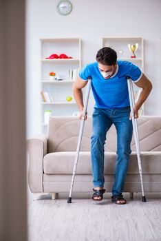 Injured man with crutches recovering at home 