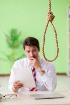Despaired businessman thinking of suicide in the office 