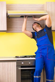 Young service contractor assembling kitchen furniture