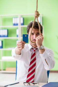Despaired businessman thinking of suicide in the office 