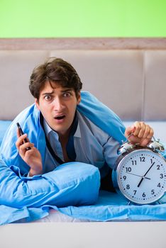 Employee in the bedroom being late for his job in time management concept