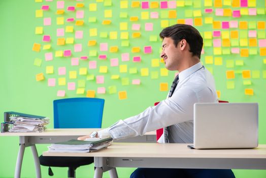 Man in the office with many conflicting priorities doing exercises  