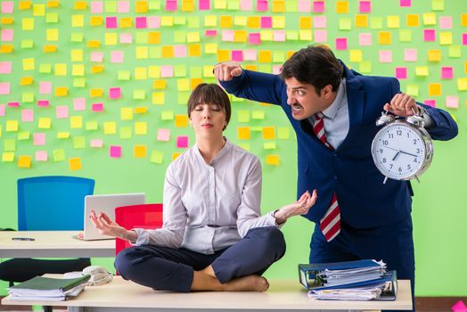 Man and woman in the office with many conflicting priorities in yoga concept  