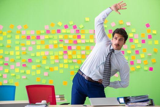 Man in the office with many conflicting priorities doing exercises  