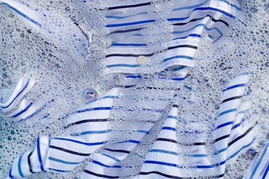 Top view of clothes soak in powder detergent water dissolution. Laundry concept