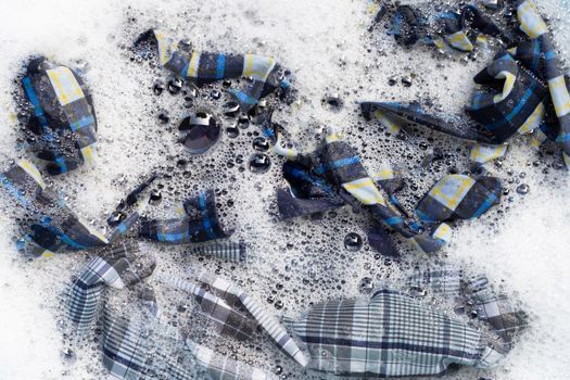 Top view of clothes soak in powder detergent water dissolution. Laundry concept