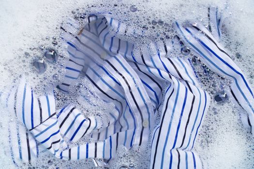 Top view of clothes soak in powder detergent water dissolution. Laundry concept