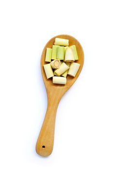 Lemongrass slices on wooden spoon on white background. 