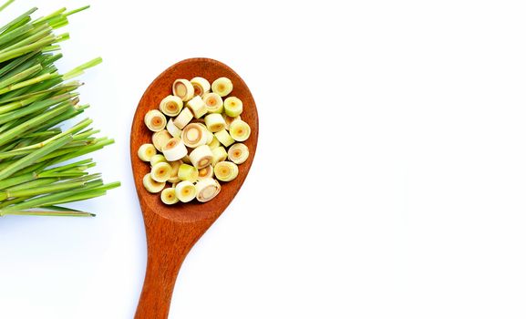 Fresh lemongrass slices on wooden spoon on white background. Copy space