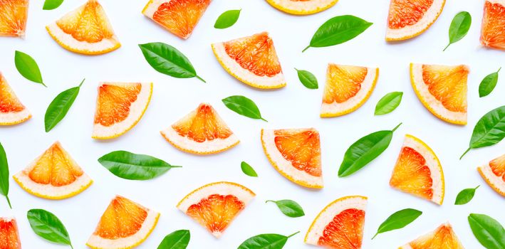 High vitamin C. Juicy grapefruit slices with green leaves on white background.