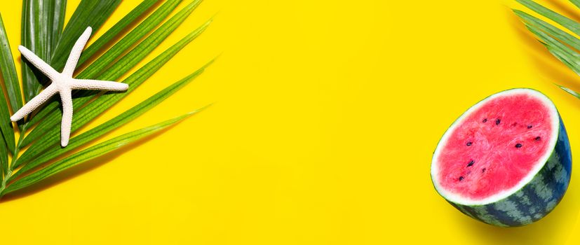 Starfish on tropical palm leaves with watermelon on yellow background. Enjoy summer holiday concept. Top view