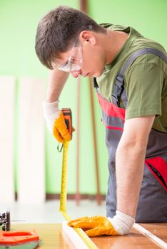 Young man carpenter working in workshop 