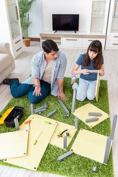 Young family assembling furniture at new house