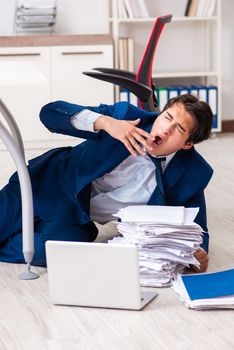 Tired exhausted businessman working overtime in office