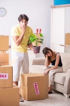 Young couple moving to new flat with fragile things