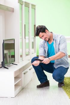 Young man husband repairing tv at home 