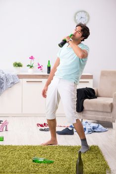 Young drunk handsome man after party at home 