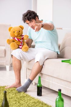 Young drunk handsome man after party at home 