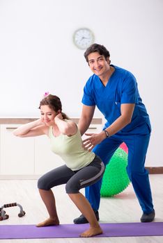 Fitness instructor helping sportsman during exercise