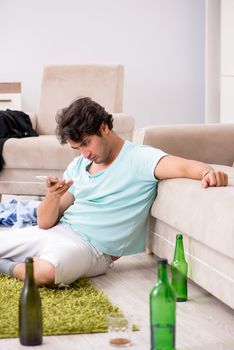 Young drunk handsome man after party at home 